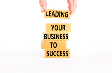 Wall Mural - Leading your business to success symbol. Concept words Leading your business to success on wooden blocks. Beautiful white table white background. Leading your business to success concept. Copy space.