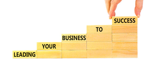 Wall Mural - Leading your business to success symbol. Concept words Leading your business to success on wooden blocks. Beautiful white table white background. Leading your business to success concept. Copy space.