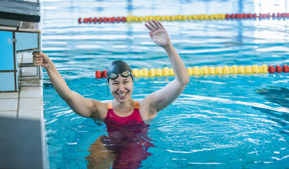 Woman swimmer happy at the finish of a race in the pool at competition