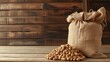 A burlap sack of peanuts on a wooden surface against a rustic background