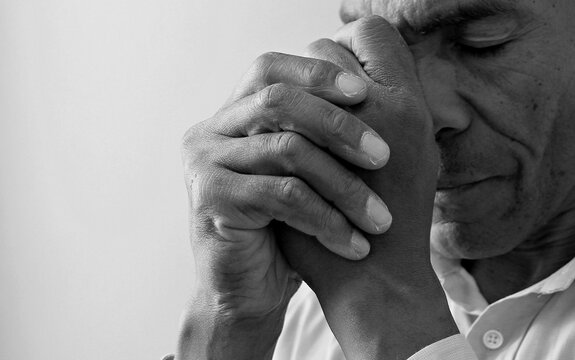 man praying to god Caribbean man praying with black grey background with people stock image stock photo	