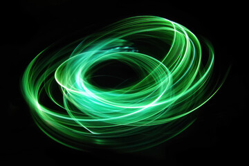 Wall Mural - A beautiful, bright light swirl of green color. Futuristic light painting on a black background. Round light circles