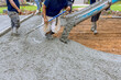 © ungvar - Using concrete mixing truck workers poured wet cement onto driveway of new house