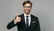 Adult smiling successful employee business man corporate lawyer wears classic formal black suit shirt tie work in office show thumb up like gesture isolated on plain grey background studio portrait