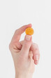 © Deidre - Woman holding orange gummy vitamin in hand