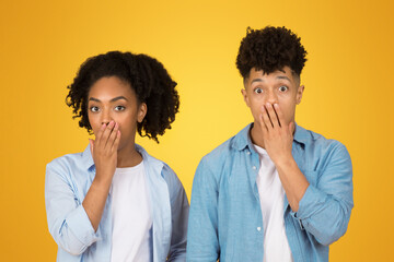 Wall Mural - A young woman and a young man in casual clothing stand side by side, both looking surprised