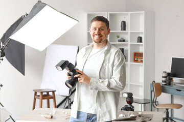 Wall Mural - Handsome photographer with professional camera in studio