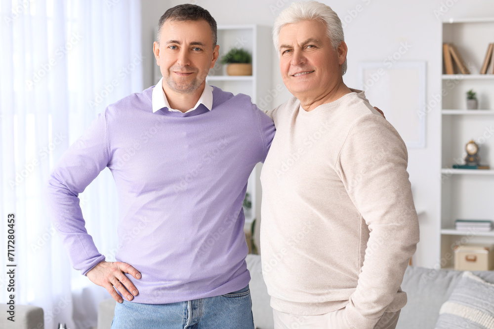Mature brothers hugging at home