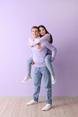 Poster - Happy young couple near lilac wall