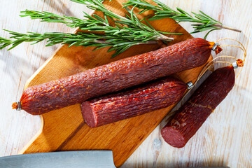 Wall Mural - Close up of Russian smoked sausage on wooden surface