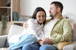 © Pixel-Shot - Happy young couple hugging on sofa at home