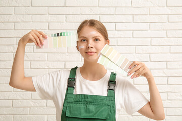 Poster - Female decorator with color samples on white brick background