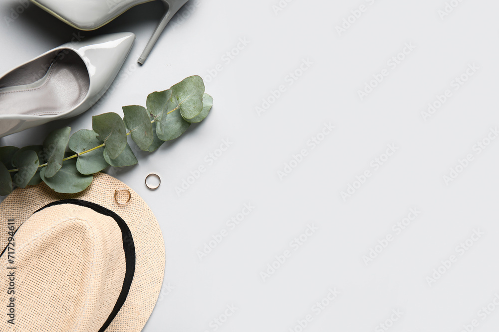 Composition with stylish female accessories, shoes and eucalyptus branch on light background