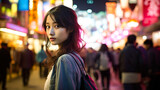Fototapeta  - 夜の繫華街に佇む若い女性