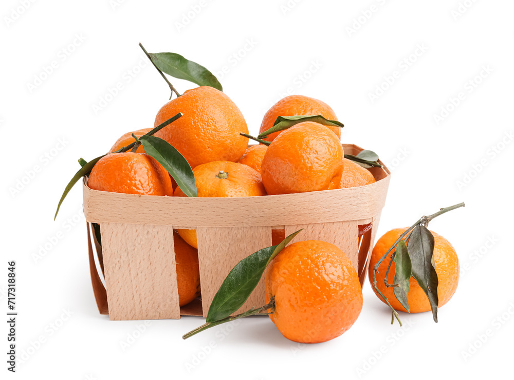 Basket with tasty tangerines and leaves on white background