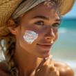 Woman at the beach with exaggerated amount of sun protection cream on her face fearing sun burning