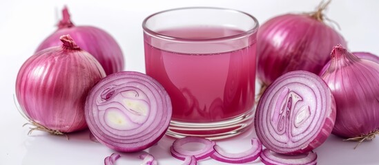 Wall Mural - Fresh organic herbal extracted Onion juice in a glass with raw onions or Allium cepa isolated on white, seen in close-up.