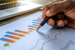© Phichitpon - close up hand Businessman review report. Graphs and charts. Business reports concept Ai generated