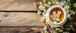 Chamomile tea and flowers on wooden background, close-up in ceramic dishes.
