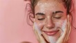 © ND STOCK - Smiling young woman washing foam face by natural foamy gel. Satisfied girl with bare shoulders applying cleansing beauty product on cheeks and closes her eyes. Personal hygiene, skincare daily routine