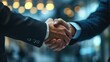 © Rudsaphon - Business Handshake Agreement Close-up,Two professionals in formal attire engage in a firm handshake, signifying a business agreement or partnership.