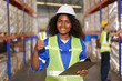 The photograph captures a mixed race-looking, fair-skinned female warehouse officer striking a confident pose for the camera inside the warehouse.