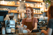 Smiling Cashier Working In Coffee Shop And Woman Paying With Credit Card