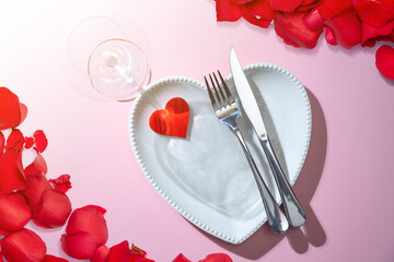 Wall Mural - Heart plate with silverware of fork and knife with a red heart and rose petal