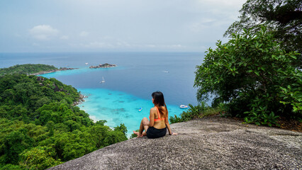 Wall Mural - Asian female stand on viewpoint sailing rock in Similan island Koh 4 view piont. Freedom traveler woman enjoy a wonderful nature. Travel concept. View Point at Similan island. Phang Nga, Thailand.