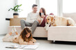 © Maria Vitkovska - Positive happy family, woman holding mobile phone, dog lying on sofa, little daughter lying on floor