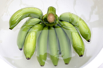 Wall Mural - Raw green bananas soaking the bananas in water. Cleaning fruits