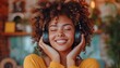 Young african american woman enjoying music in her cozy living room, wearing headphones and dancing with a carefree and joyful expression, capturing the essence of a relaxed and stylish lifestyle.
