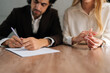 © dikushin - Cropped shot of spouses couple signing decree papers getting divorced in lawyers office at desk. Unhappy married family split break up end relationships giving permission to marriage dissolution.