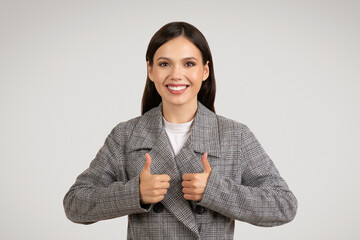 Happy businesswoman giving two thumbs up and smiling