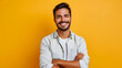 © SS Digital - Rich, self-assured man standing alone with a smile against a yellow backdrop. Happy, attractive, ethnic man in a shirt glancing at a camera while posing for a portrait with his arms crossed