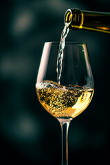 Wall Mural - Pouring wine into a glass close-up. Selective focus.