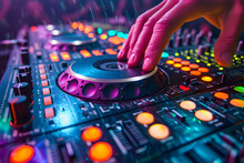 DJ's hand mixing music on a colorful, illuminated club mixer at a party.