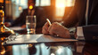 © MP Studio - Man in a business suit sitting at a desk, writing or signing a document with a pen