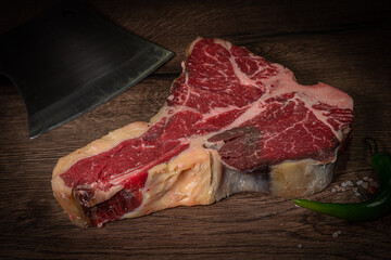 Poster - Raw beef steak with spices on a dark slate, stone or concrete background. Top view with copy space.