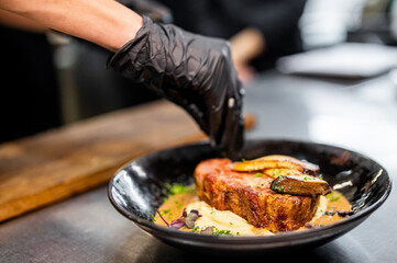 Wall Mural - Professional chef cooking Grilled beef steak with mashed potato and sauce in restaurant kitchen