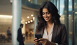 © AJay - A smiling young Indian businesswoman communicating on her mobile phone in a corporate environment