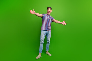 Poster - Full length photo of optimistic friendly man wear stylish t-shirt jeans stretching arms to hug you isolated on green color background