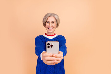 Poster - Photo of excited cheerful woman wear stylish blue clothes looking screen wondering modern technology isolated on beige color background