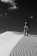 Sexy Asian girl in bikini and pants posing in sand desert