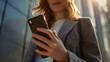 © pathiphan - Woman smiling while using her mobile phone for texting, combining technology and business communication