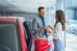 © Dragana Gordic - Shot of a young couple looking at cars at a car dealership.  It is the one car I want! Beautiful young couple standing at the dealership choosing the car to buy