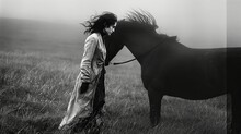 Young Woman In Black Dress With Her Black Horse Outdoor.