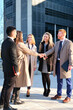 © Ladanifer - Team of business people negotiating an agreement closing the deal with a client at business buildings street area.
