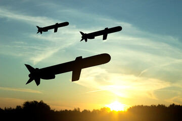 Wall Mural - Silhouettes of Tomahawk cruise missiles against the sunset