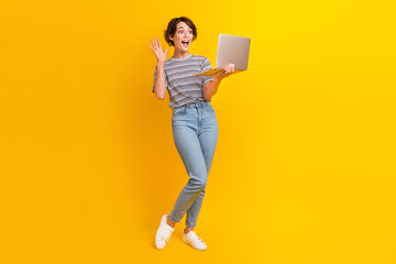 Poster - Full length photo of excited attractive person arm waving hi video call laptop isolated on yellow color background